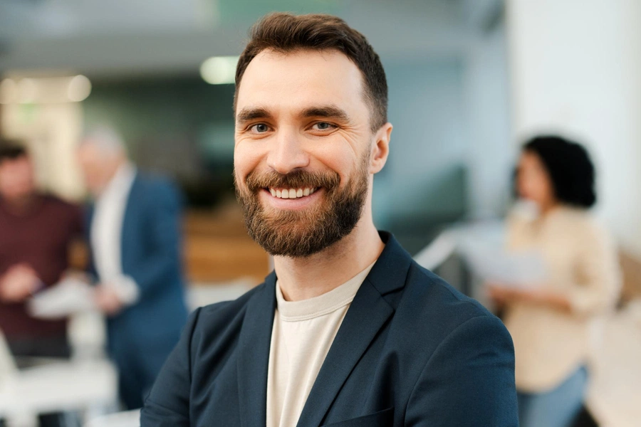 Male behavioral health professional with beard smiling in office setting