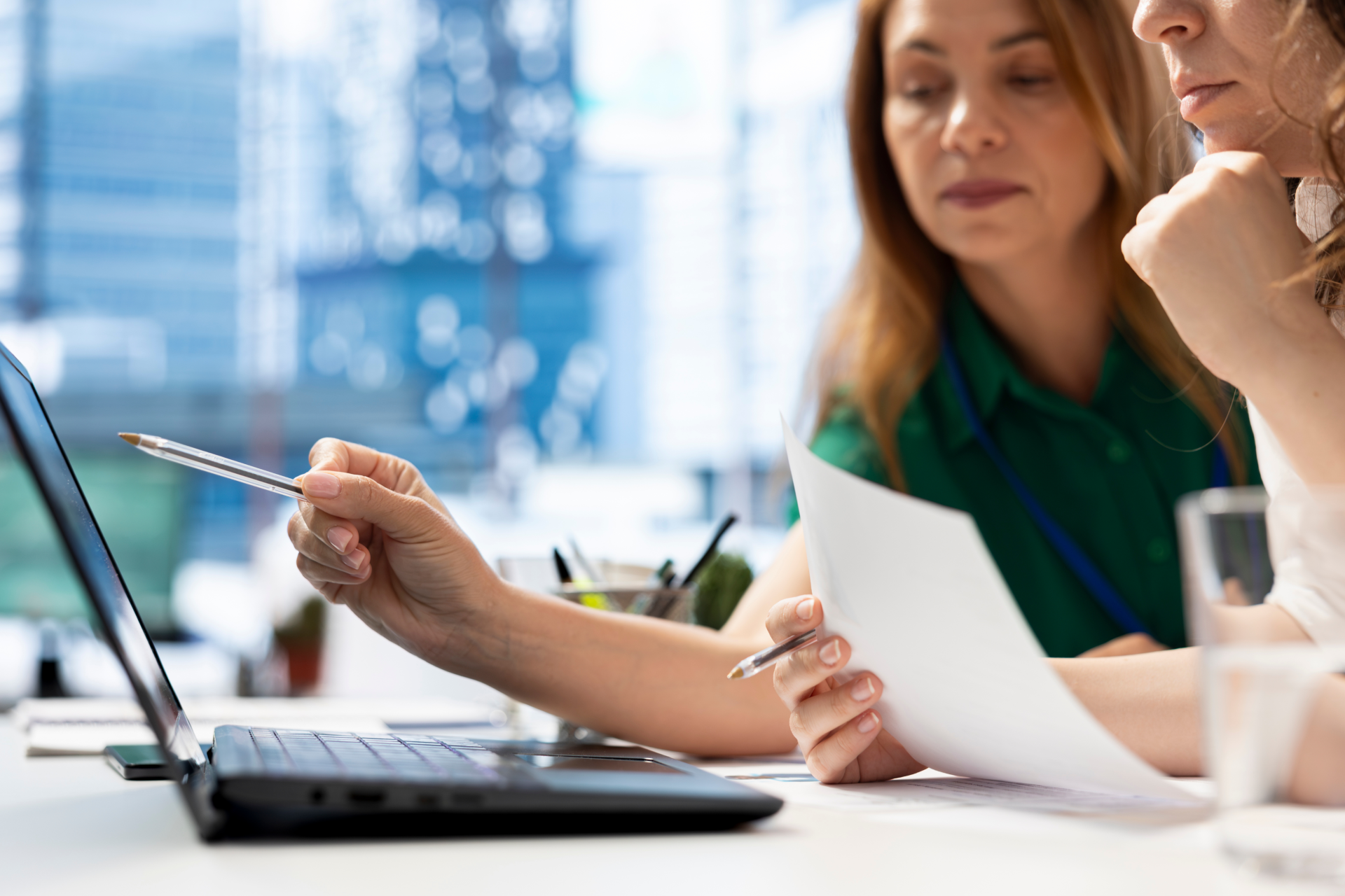 Two healthcare professionals collaborating over a laptop in an office